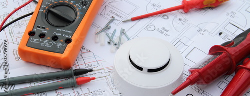 smoke detector with a screwdriver and a measuring device on a circuit diagram photo