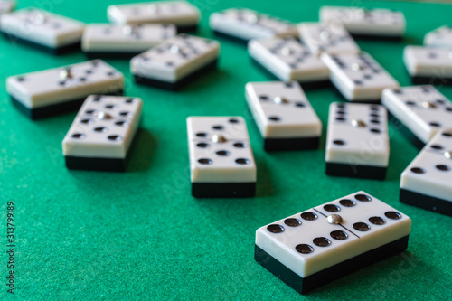 Top view of domino pieces  the six double focused  the rest out of focus  on horizontal green mat