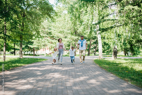 Big family with two kids walk in the park.
