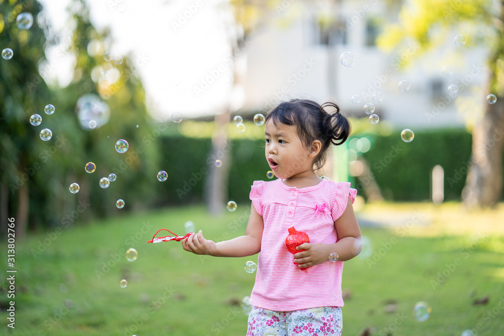 Cute little girl playing with bubbles in park. Cute little girl playing with bubbles in park.