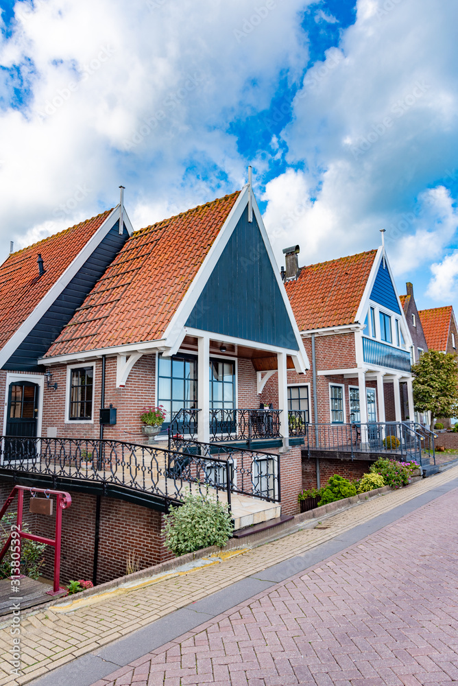 Country wooden house surrounded by green trees. Volendam village in the Netherlands.