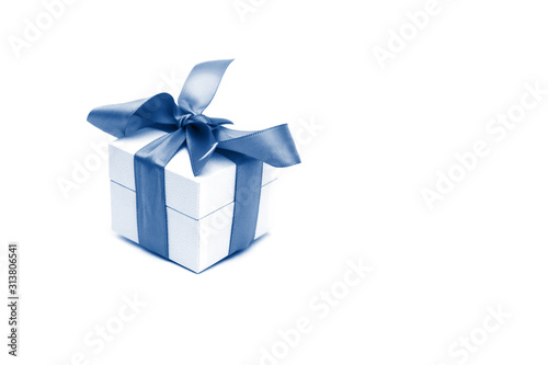 A gift box isolated over white background with copy space. Box is tied with a ribbon. Tinted by 2020 year Classic Blue color. Valentine`s Day, 8 March, Mother and Women Day concept © Дмитрий Березнев