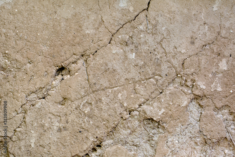 Cracked beige clay wall. Background. Texture Cracked beige clay wall. Background. Texture