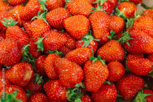 A lot of ripe, fresh strawberry berries lying in a box. photo