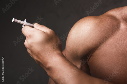 Muscular man with a syringe in his hand