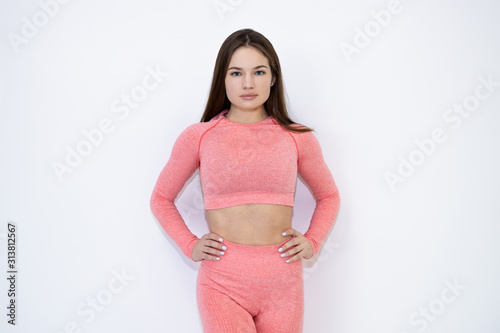 Portrait of a beautiful girl fitness trainer on a white background