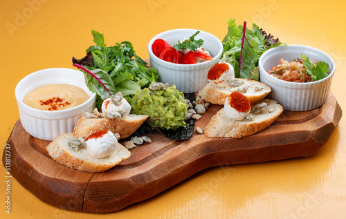 Board with delicious snacks. Guacamole, eggplant with Dor blue, sheep cheese with paprika eggplant puree.