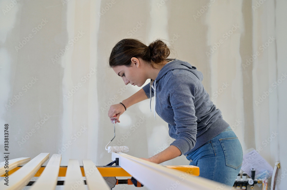 Apprentice in construction industry painting wood