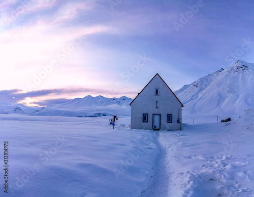 Church on the snowy Cross Pass on the Georgian Military Highway during sunset