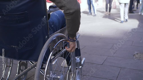 Wallpaper Mural young disable man pushing his wheelchair on the crowded sidewalk - slow motion Torontodigital.ca