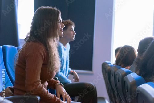 Group of university multiethnic students listening presentation from their professor in the big modern conference hall.