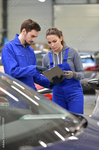 Apprentice in car industry using digital tablet