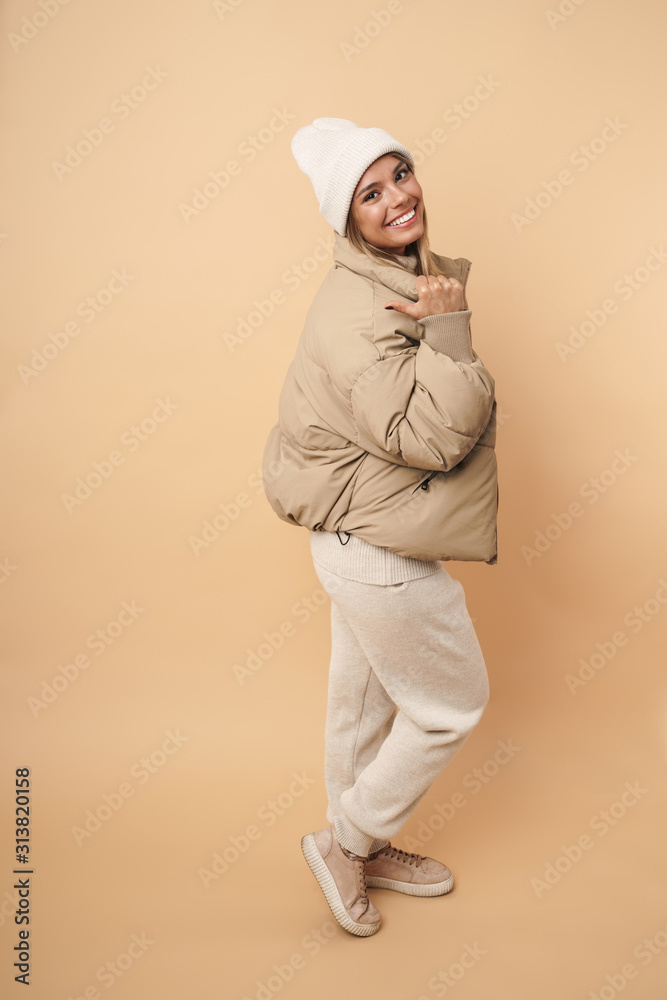 Portrait of smiling young woman pointing thumb aside Portrait of smiling young woman pointing thumb aside