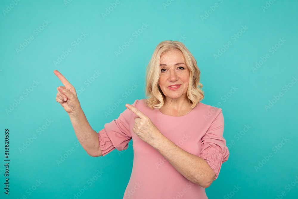 Woman in the pink clothes standing isolated and pointing something by fingers Woman in the pink clothes standing isolated and pointing something by fingers