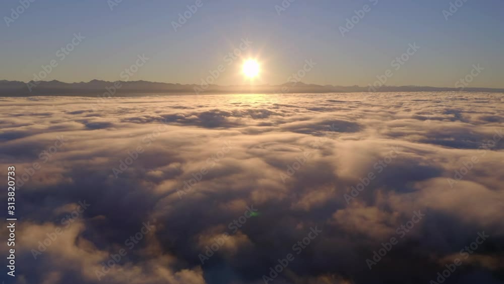 flying high over the clouds during a beautiful sunrise flying high over the clouds during a beautiful sunrise