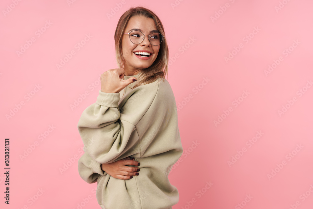 Portrait of young smiling woman pointing finger at copyspace Portrait of young smiling woman pointing finger at copyspace