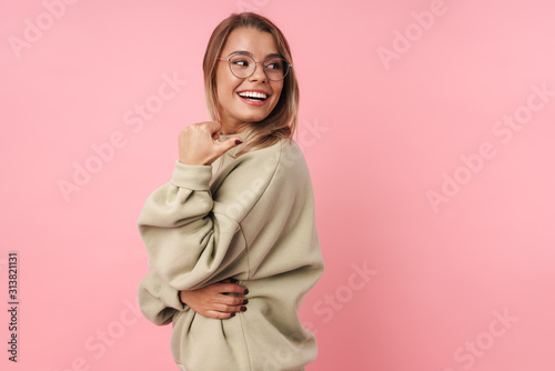 Portrait of young smiling woman pointing finger at copyspace © Drobot Dean