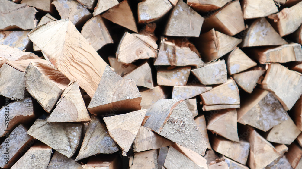 A neatly folded log of chopped wood. The fire is melting. Firewood stacked on top of each other. Firewood is collected for heating in cold weather. Background texture of stacked dry firewoods A neatly folded log of chopped wood. The fire is melting. Firewood stacked on top of each other. Firewood is collected for heating in cold weather. Background texture of stacked dry firewoods