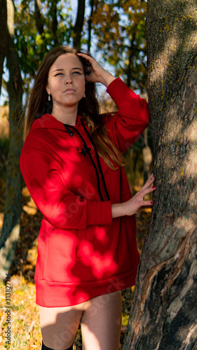 Incredible stunning girl in a red dress. The background is fantastic autumn. Artistic photography.
