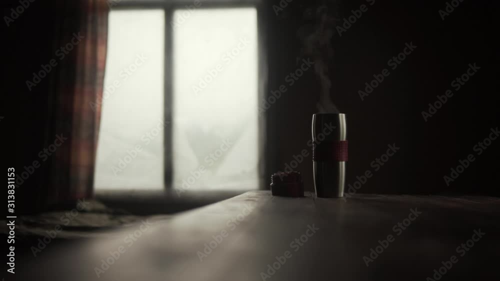 Steaming coffee or tea in a thermo cup on texture table. Dark atmosphere Steaming coffee or tea in a thermo cup on texture table. Dark atmosphere