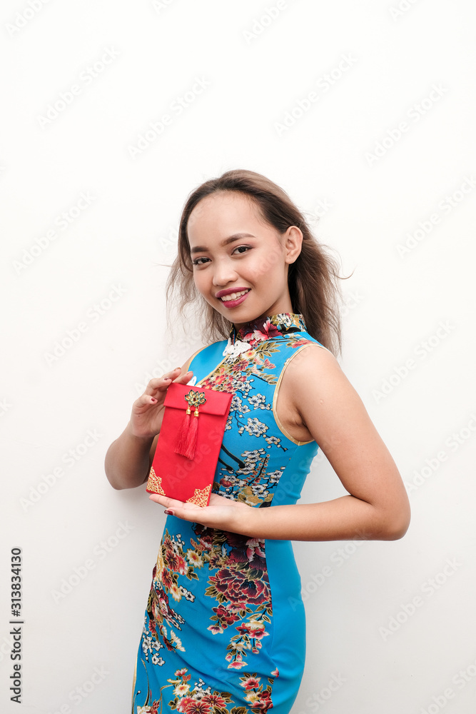 Young Female wearing a traditional blue qipao or cheongsam celebrating Chinese New Year recieving Ang Pao or Money in red envelope. Young Female wearing a traditional blue qipao or cheongsam celebrating Chinese New Year recieving Ang Pao or Money in red envelope.