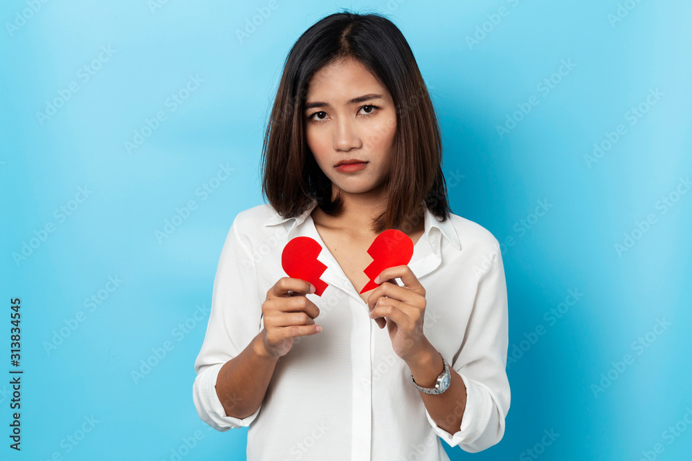 asian woman holding broken paper red heart ,valentine concept isolated on blue background asian woman holding broken paper red heart ,valentine concept isolated on blue background