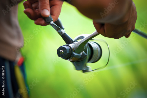 A man fishing on a summer day. A man holding a fishing rod. Green background. 