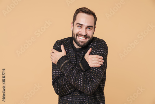 Cheerful young bearded man wearing warm sweater