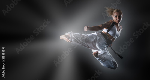 Composite image of karate girl jumping