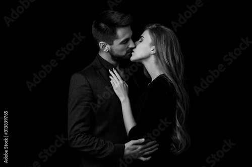 elegant couple in the tender passion. man and beautiful woman kissing. black and white
