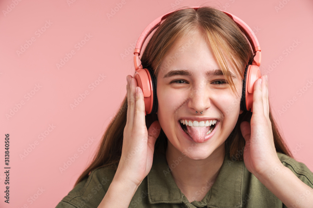 Photo of cheerful young woman using headphones and making fun Photo of cheerful young woman using headphones and making fun