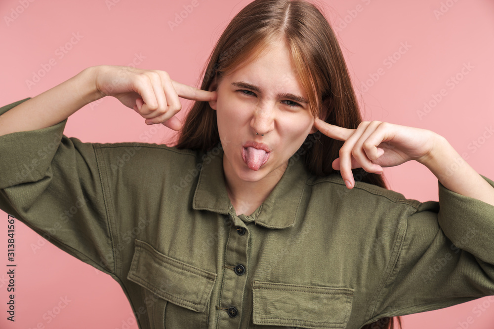 Photo of displeased woman plugging her ears and sticking out her tongue Photo of displeased woman plugging her ears and sticking out her tongue