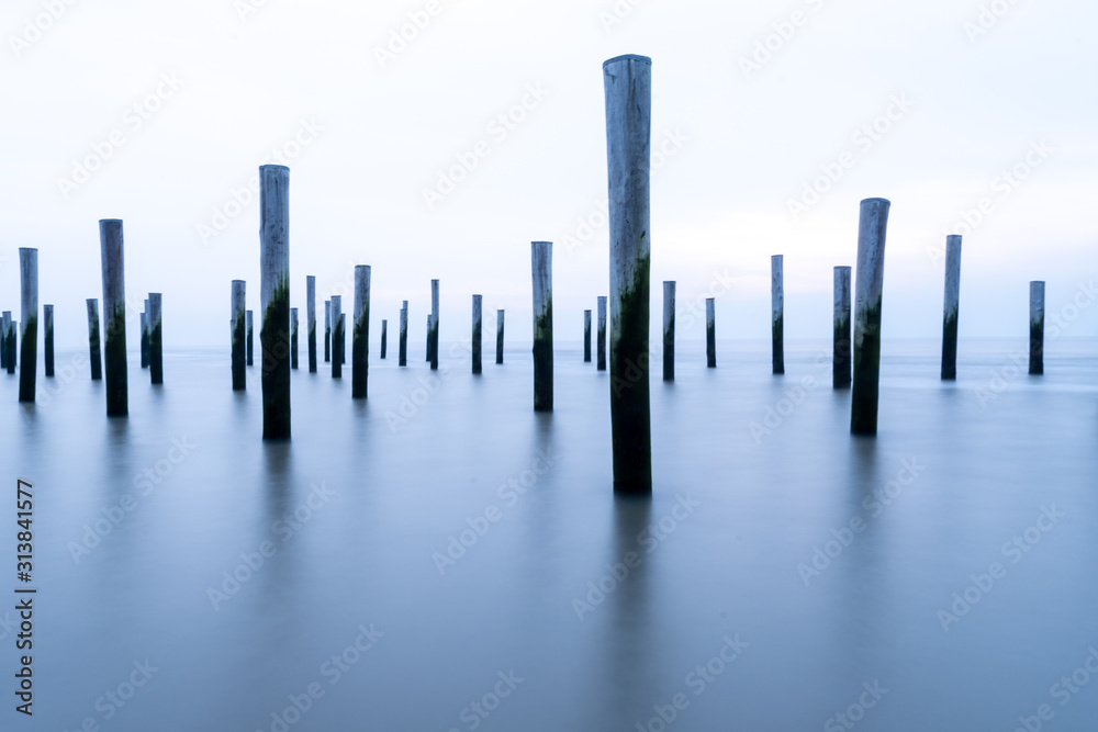 Poles at the sea during blue hour Poles at the sea during blue hour