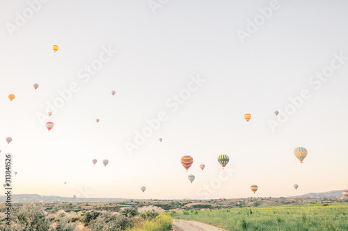 Hot air balloons flying over rock landscape in Love valley at Cappadocia, Turkey 