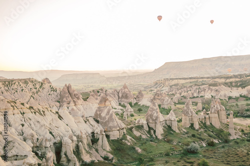 Hot air balloons flying over rock landscape in Love valley at Cappadocia, Turkey 