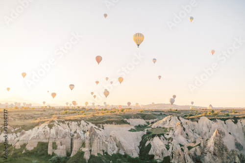 Hot air balloons flying over rock landscape in Love valley at Cappadocia, Turkey 