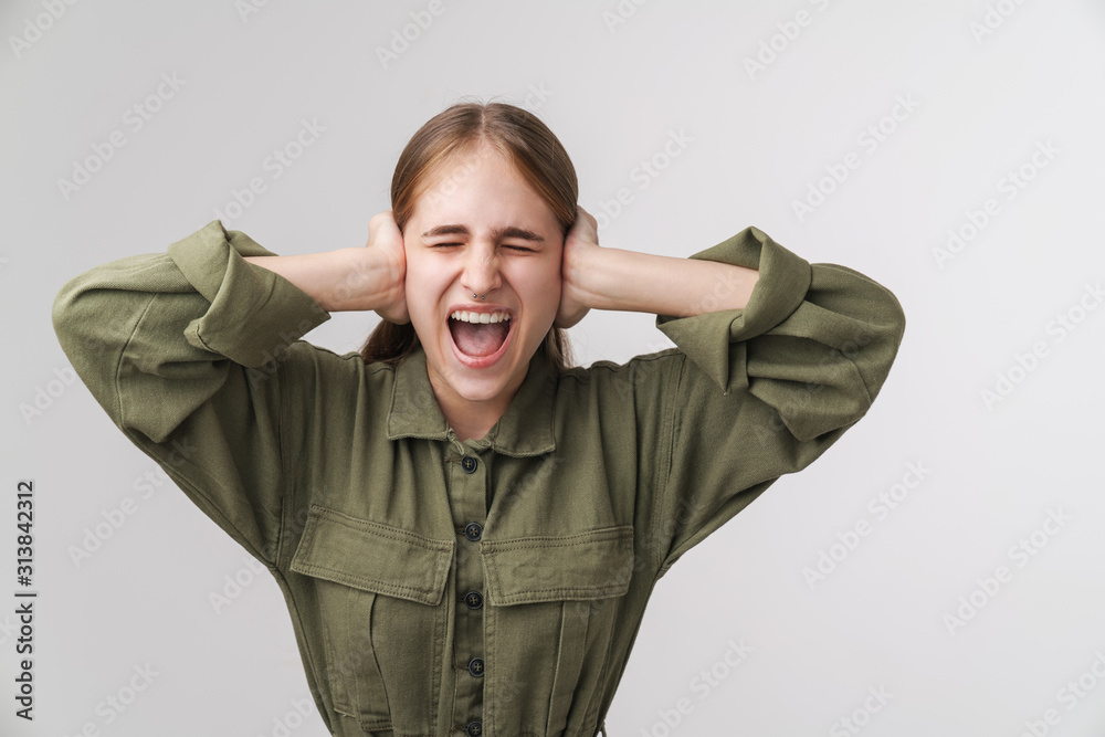 Photo of annoyed young woman screaming and grabbing her head Photo of annoyed young woman screaming and grabbing her head