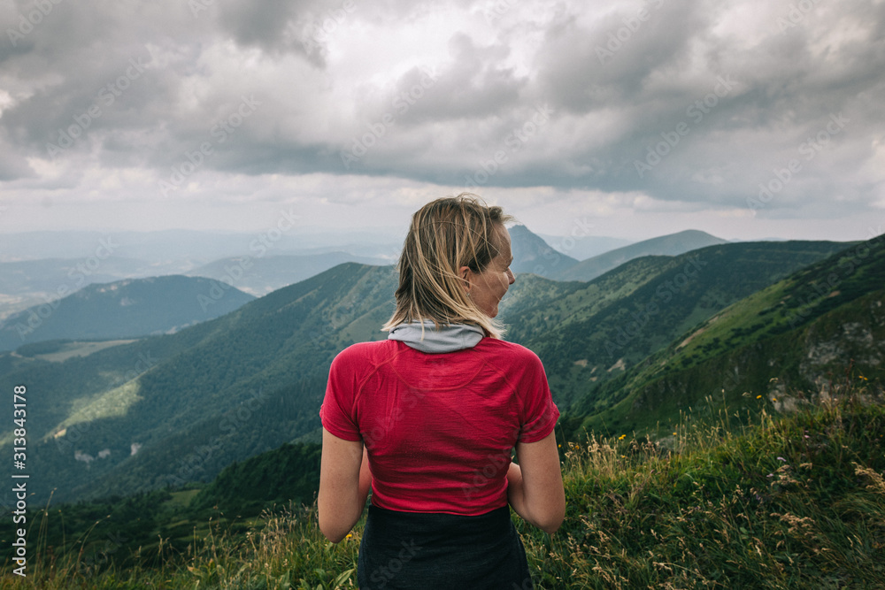 woman in red t-shirt looks at mountains