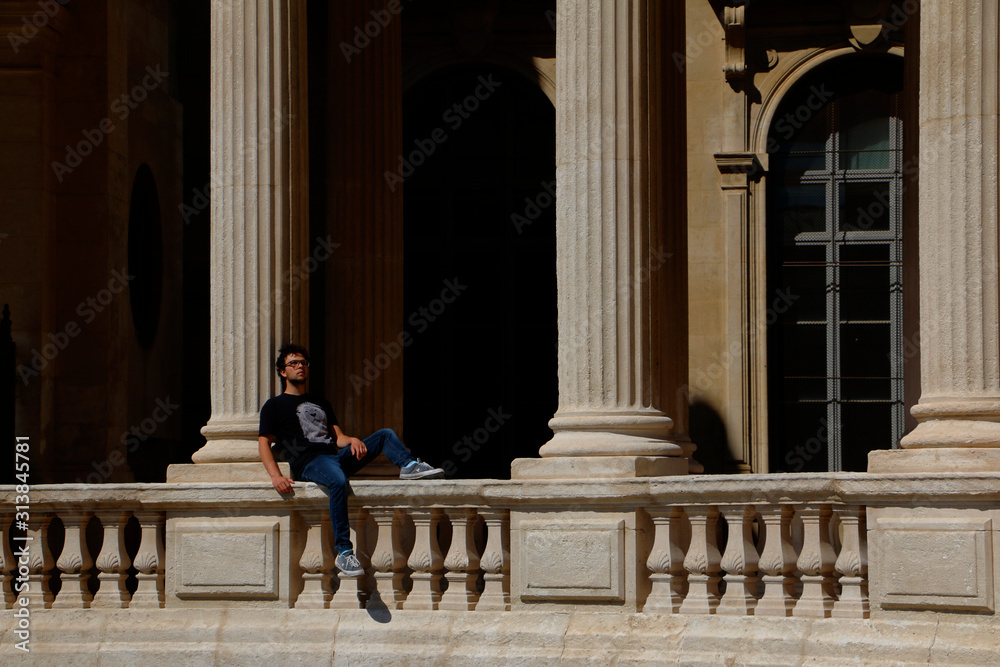 Male teenage model sitting thoughtfully between ancient columns Male teenage model sitting thoughtfully between ancient columns