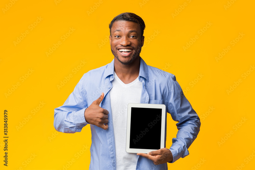 Afro Man Showing Tablet Screen Gesturing Thumbs-Up, Mockup, Studio Shot Afro Man Showing Tablet Screen Gesturing Thumbs-Up, Mockup, Studio Shot