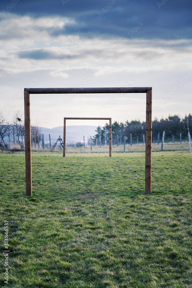 Two wooden soccer goals on green grass field, healthy active lifestyle and new years resolution concept