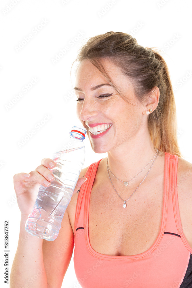 Sporty woman laughing smiling drinking with water bottle in white background Sporty woman laughing smiling drinking with water bottle in white background