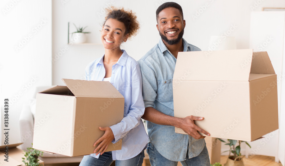 Young Couple Carrying Moving Boxes Into New House Young Couple Carrying Moving Boxes Into New House