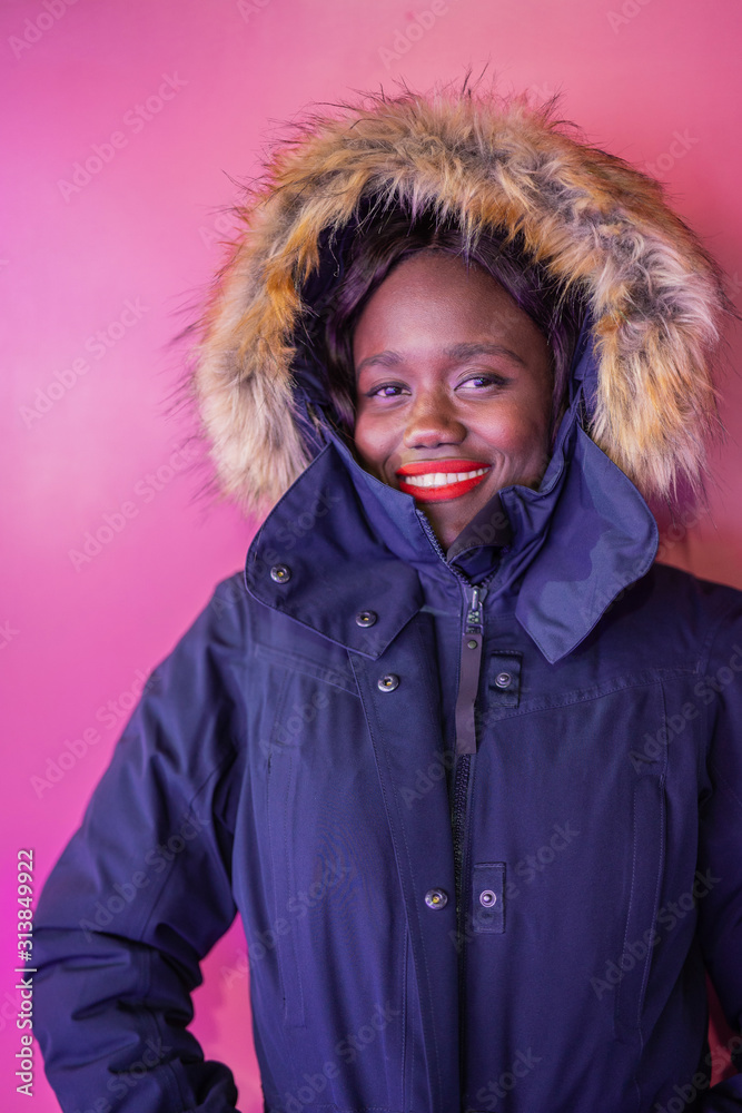 Black young woman looking to camera over pink background Black young woman looking to camera over pink background