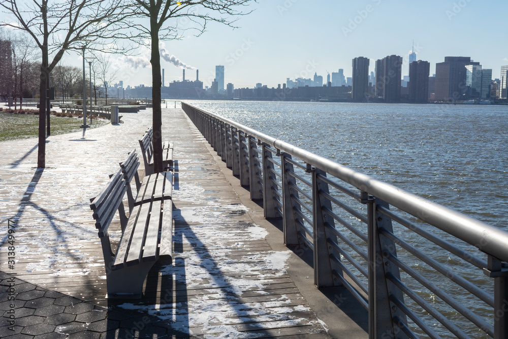 Empty Benches along the East River in Long Island City Queens New York looking out towards the Manhattan Skyline Empty Benches along the East River in Long Island City Queens New York looking out towards the Manhattan Skyline