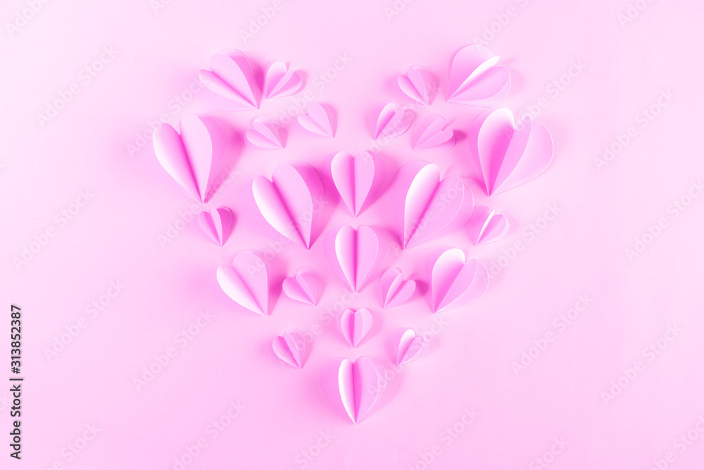 Pink paper elements in shape of heart flying on pastel pink background. Valentine's Day concept. Happy Women's, Mother's, Valentine's Day, birthday greeting card.