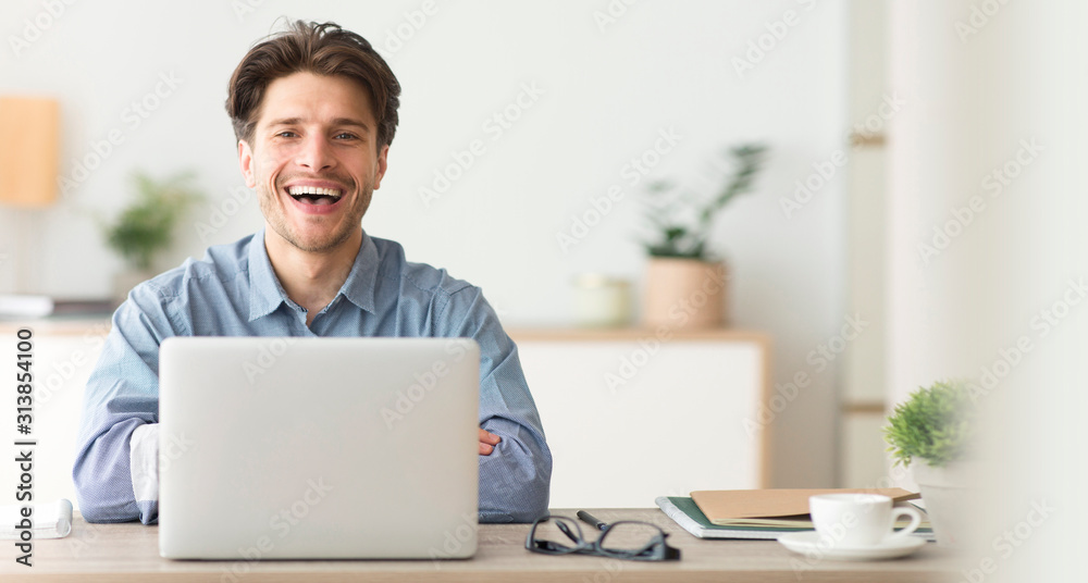 Happy Employee Smiling At Camera While Working On Laptop In Office - obrazy, fototapety, plakaty 