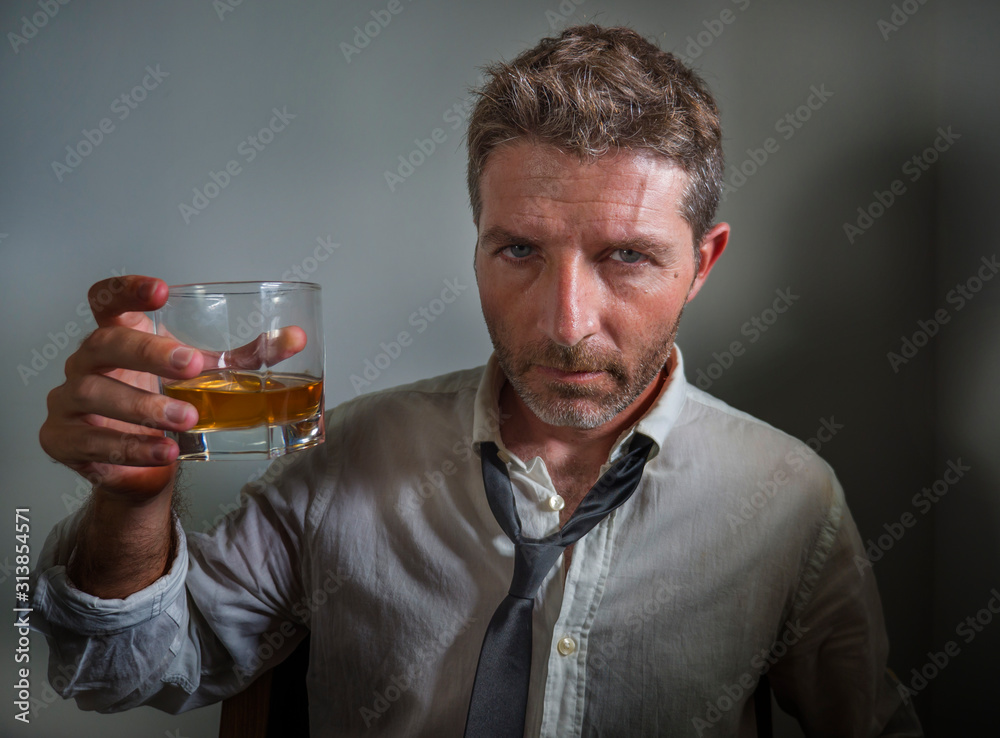 portrait of 30s to 40s alcoholic man in lose necktie drinking desperate holding whiskey glass thoughtful drunk and depressed completely wasted in alcohol addiction concept portrait of 30s to 40s alcoholic man in lose necktie drinking desperate holding whiskey glass thoughtful drunk and depressed completely wasted in alcohol addiction concept