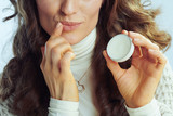 Closeup on modern housewife applying lip balm