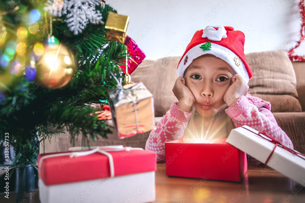 Happy a little girl with a glowing Christmas gift box, Christmas and New Year concept. Happy a little girl with a glowing Christmas gift box, Christmas and New Year concept.